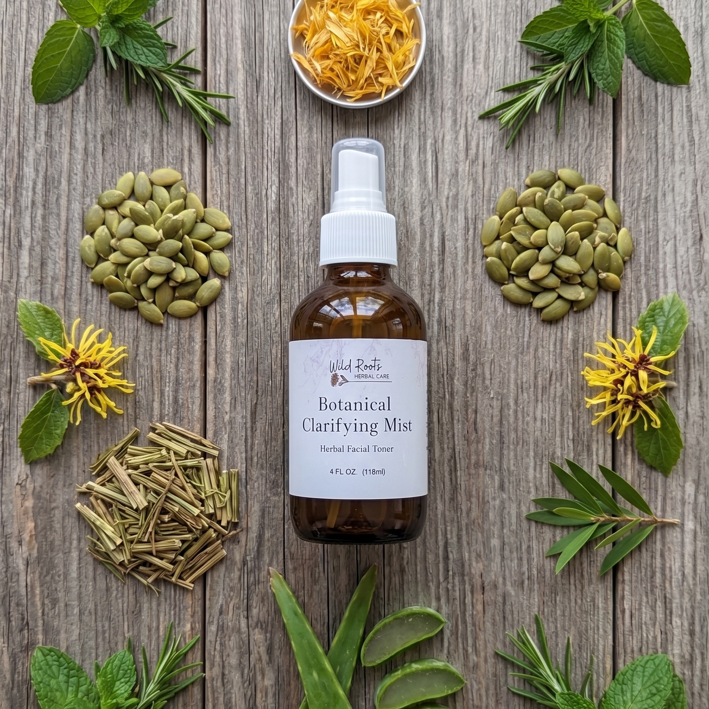 A bottle of Wild Roots Botanicals Botanical Clarifying Mist is centered on a rustic wooden background, surrounded by its natural ingredients including mint, aloe vera, rosemary, pumpkin seeds, and yellow flowers.