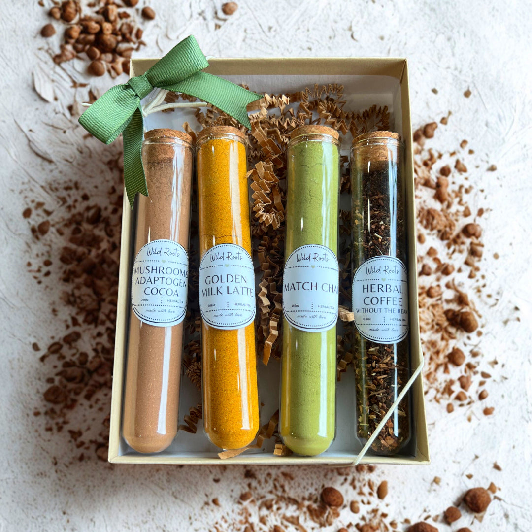 Four glass tubes with different colored liquids in a box with a green ribbon, surrounded by brown powder on a light background.