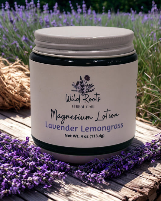 4oz Lotion jar labeled 'Wild Roots' with lavender lemongrass Magnesium lotion on a wooden surface. for headaches, sore muscles, cramps, aches, pains, deep sleep