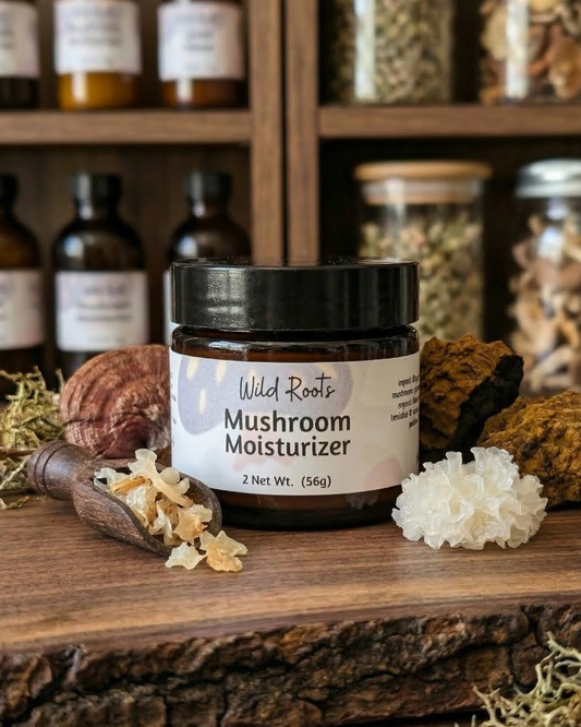Mushroom moisturizer jar on a wooden surface with herbs and bottles in the background. mushroom cream, Tallow, snow mushroom, reishi, chaga , gotukola
