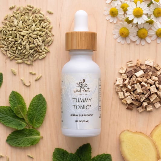 Tummy tonic bottle with natural ingredients on a wooden surface
