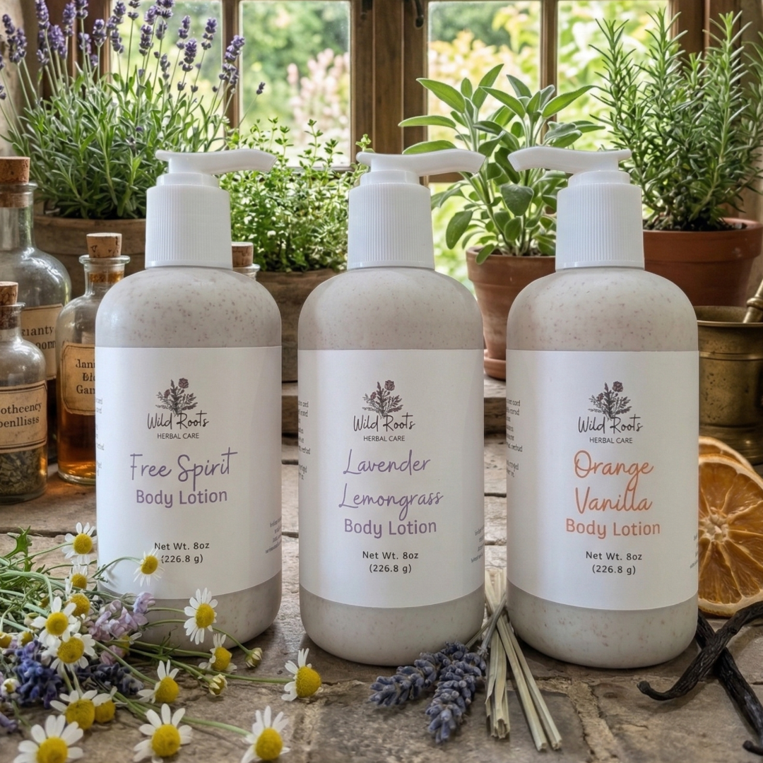Three bottles of Wild Rootz body lotion on a rustic stone surface with herbs and flowers.