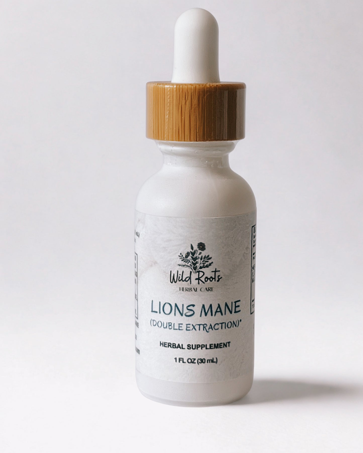 Bottle of Wild Roots Lions Mane supplement with a dropper on a white background