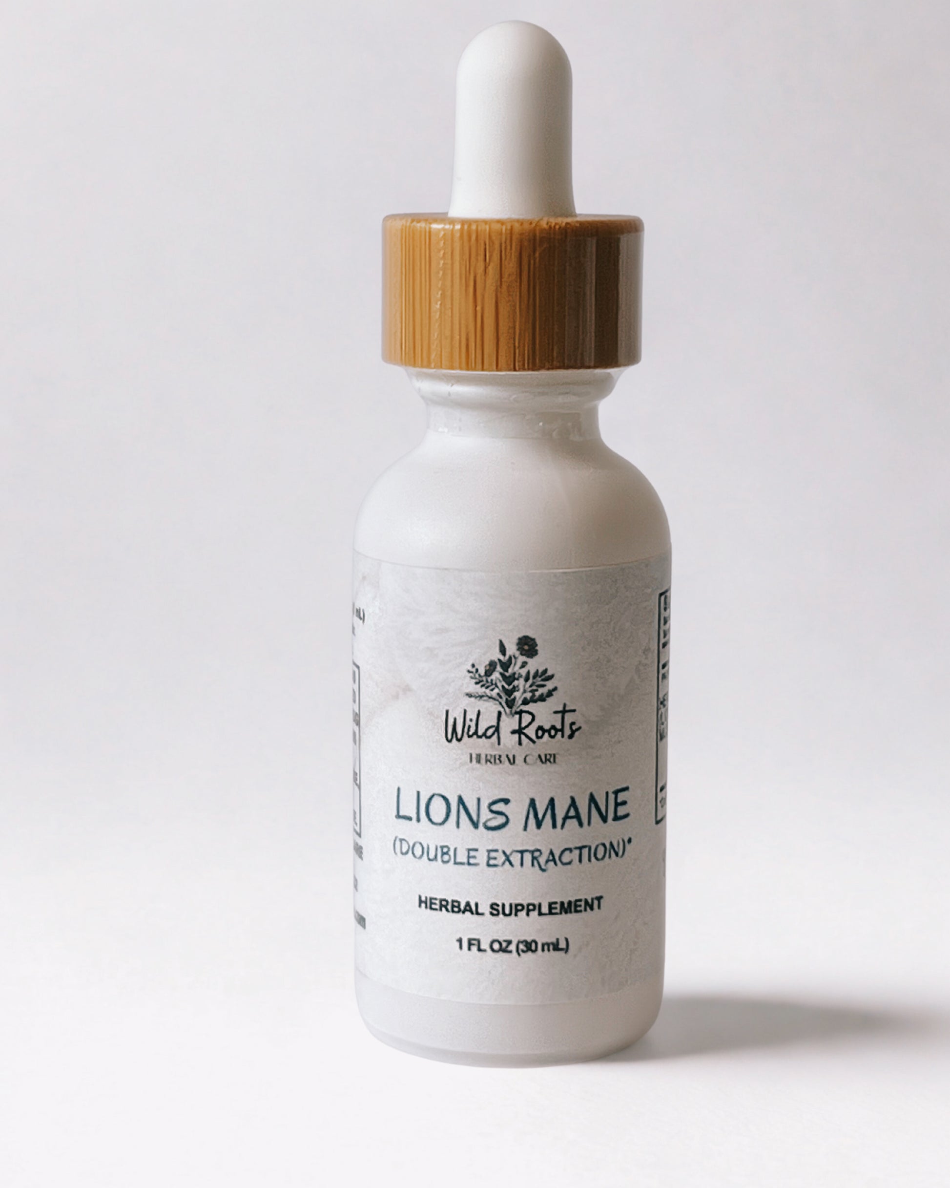 Bottle of Wild Roots Lions Mane supplement with a dropper on a white background