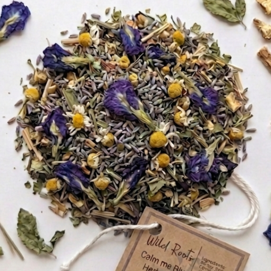 Tea-making setup with dried herbs, a jar of tea leaves, and a mug on a wooden surface.