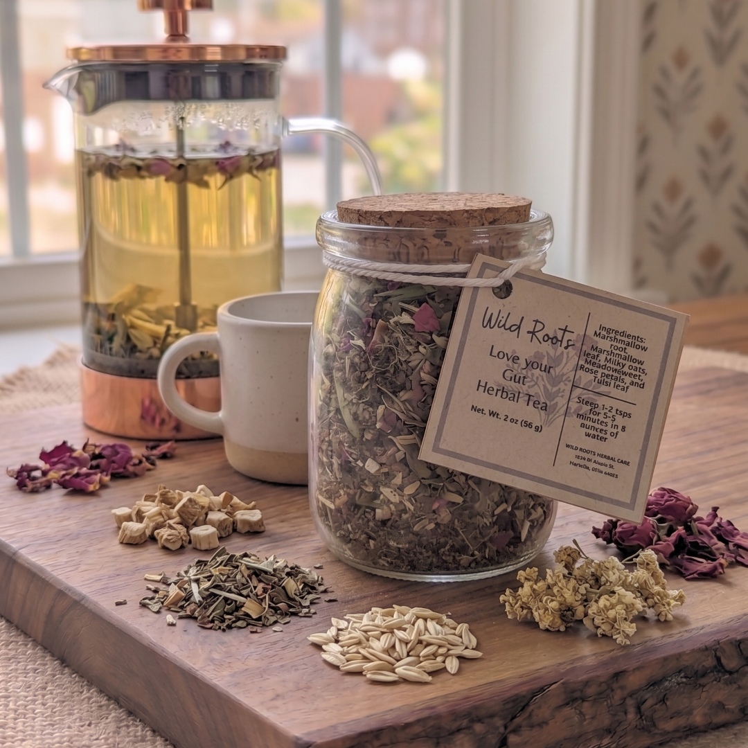 Tea-making setup with a jar of dried herbs, a French press, and a tag on a wooden board.