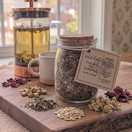 Tea-making setup with a jar of dried herbs, a French press, and a tag on a wooden board.
