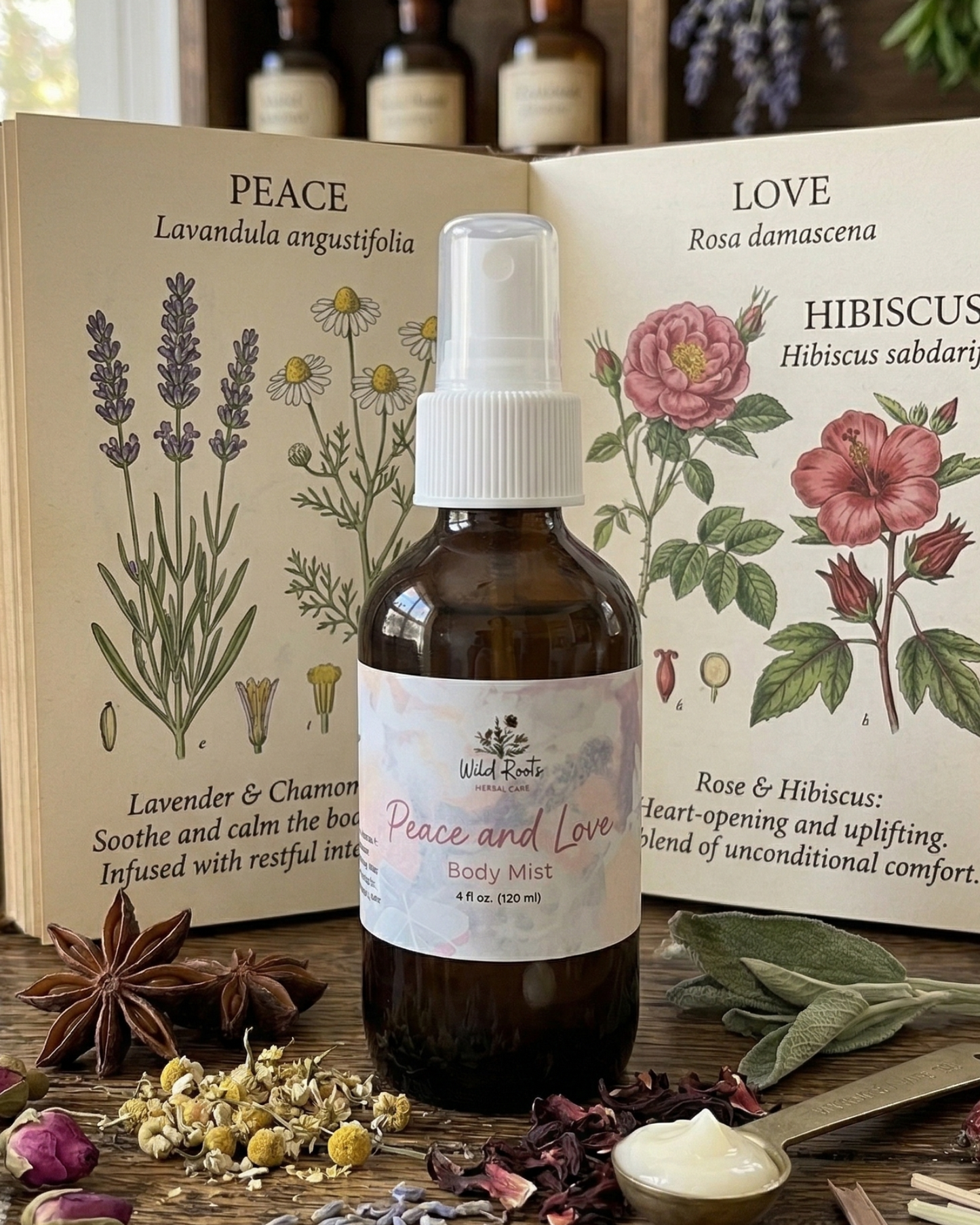 Bottle of 'Peace and Love' body mist on a wooden surface with botanical books and herbs.
