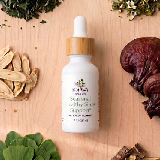 White dropper bottle labeled 'Seasonal Healthy Sinus Support' surrounded by dried herbs on a wooden surface.