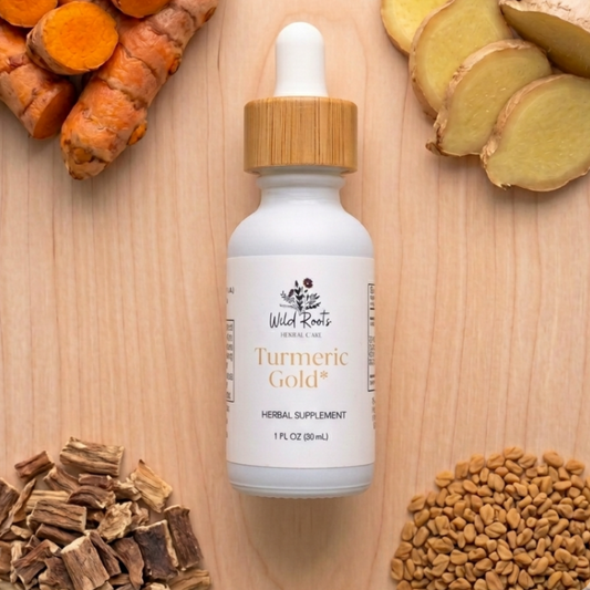 Bottle of Wild Roots Turmeric Gold supplement surrounded by turmeric roots, ginger, and fenugreek seeds on a wooden surface.